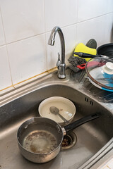 Used and dirty cooking utensils and equipment was placed near the sink to wait for cleaning.