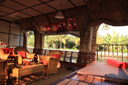 View of a houseboat interior is comfortably furnished with an open lounge sailing on the Kerala backwaters in Alleppey, Kerala, India