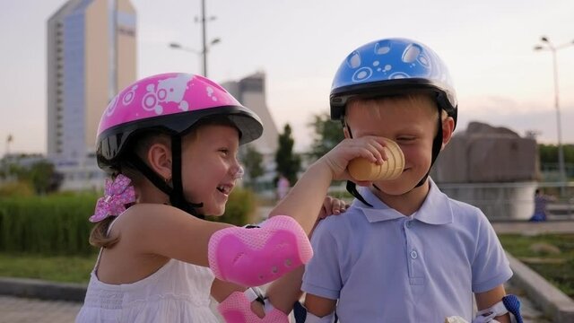 Little funny children have fun in the Park in the summer, they smear each other with ice cream.