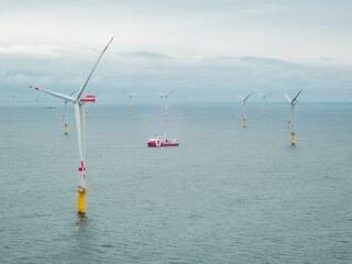 wind turbine in the ocean with a boat