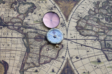 Fototapeta na wymiar Classic round compass on background of old vintage map of world as symbol of tourism with map and compass, travel with with map and compass and outdoor activities with with map and compass