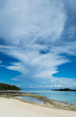 雄大な雲が浮かぶ快晴の遠浅でエメラルドグリーンの海岸