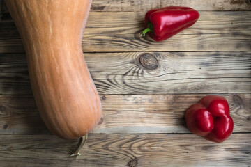 Pumpkin and sweet red pepper on a wooden background.