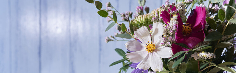 Banner, Bouquet of wild flowers on a blue wall background 