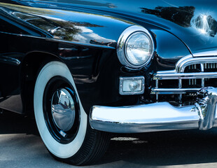 Retro car show. Black classic retro car. Vintage car fragment.
Black GAZ 12 ZIM at the at the retro car show