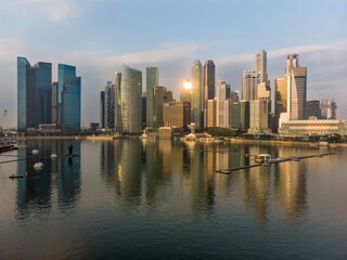 El skyline del distrito financiero de Singapur al amanecer y reflejado sobre Marina Bay