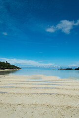遠浅の白い砂紋のある海岸と快晴の空