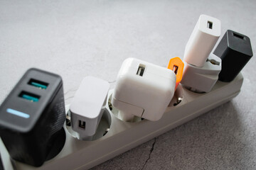 Close up of running modern extension power strip with many different USB DC output ports. Cracked concrete background. Copy space