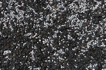 Closeup black asphalt background with white pebbles