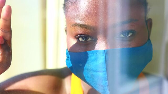 african american woman feeling alone at her home looking to outdoors from her apartment balcony