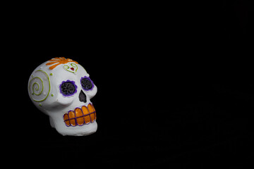 a skull head of the day of the dead painted by hand on a black background