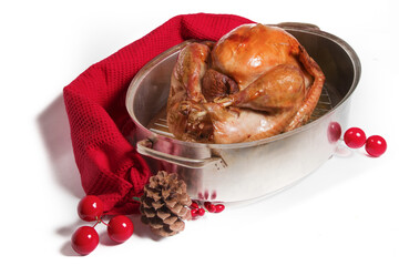 Christmas dinner roasted turkey in a roasting pan with Christmas decorations isolated on white