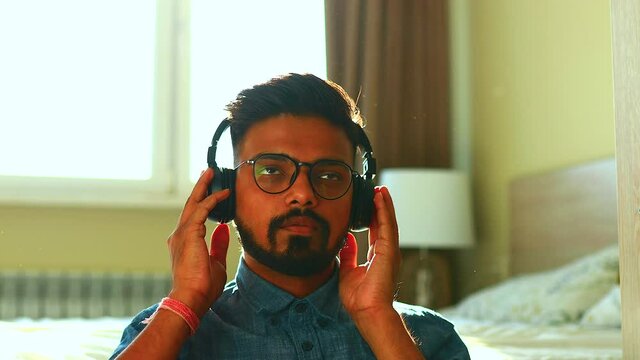 Indian Young Man Wearing Noise Canselling Headphones Relaxing, Listening Personal Growth Training At Home Self-isolation