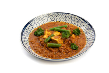 a blue dish of Indian buttered chicken isolated on a white background