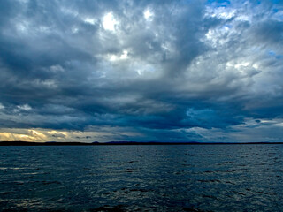 dark overcast sky over the lake on a summer evening, gloomy clouds