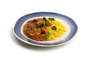 a blue plate of Indian buttered chicken with green beans and curry rice isolated on a white background