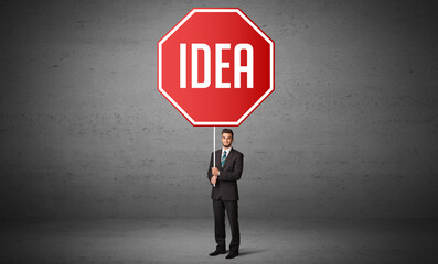 Young business person holding road sign with IDEA inscription, new rules concept