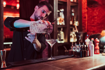 Bartender mixing cocktail in pub