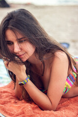 Young women in a colored swimsuit sunbathing on the beach