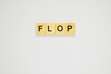 Word flop. Wooden blocks with lettering on top of white background. Top view of wooden blocks with letters on white surface