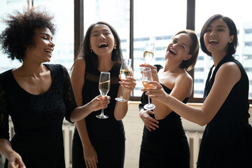 Overjoyed pretty positive young diverse ladies in classy black dresses having fun, celebrating...