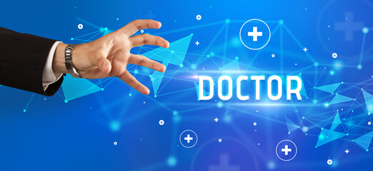 Close-Up of cropped hand pointing at DOCTOR inscription, medical concept