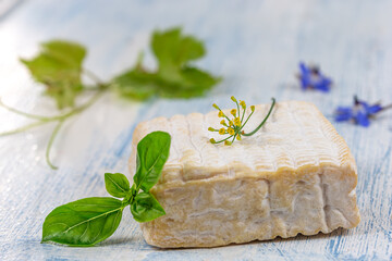 A block of Pont-l eveque French Normandy cheese resting on wooden board