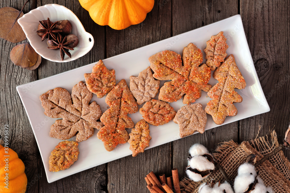 Aufkleber Autumn table scene with spiced leaf cookies. Top view on a rustic wood background.