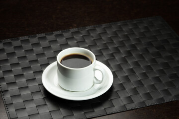Cup of coffee over the black background