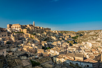 Fototapeta na wymiar Matera, Basilicata, Italy - Panoramic view from the top of the Sassi of Matera, Barisano and Caveoso. The ancient houses of stone and brick, carved into the rock. The ravine in the background.