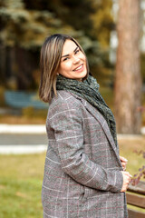 Portrait of a young woman in casual plus-size clothing on the background of autumn foliage in the Park