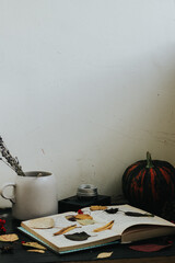 autumn composition on a dark background, cozy atmosphere, tea, books, foliage