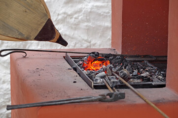 bellows of the blacksmith fanning the fire in the coals