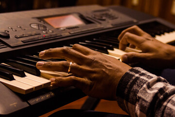 mão com aliança tocando teclado