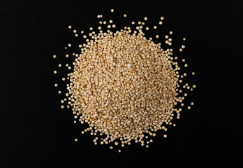 Heap of quinoa seeds isolated on black background