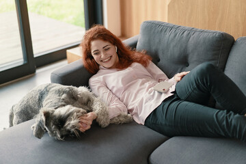 Portrait of beautiful young woman playing with her dog