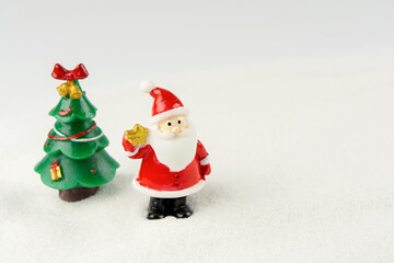 Merry Christmas and happy new year concept. Cute santa claus figure and tree on snow with copy space
