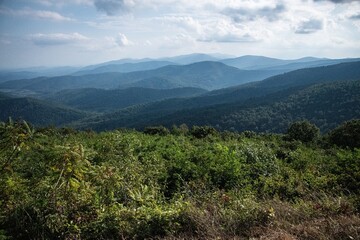 Blue ridge mountains with clouds, sunlight, and greenery