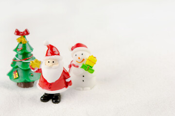 Merry Christmas and happy new year concept. Cute santa claus figure and tree on snow with copy space