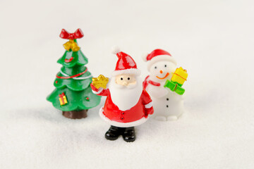 Merry Christmas and happy new year concept. Cute santa claus figure and tree on snow with copy space