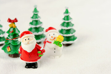 Merry Christmas and happy new year concept. Cute santa claus figure and tree on snow with copy space