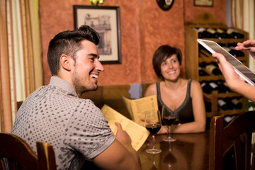 waitress taking order in bar to couple