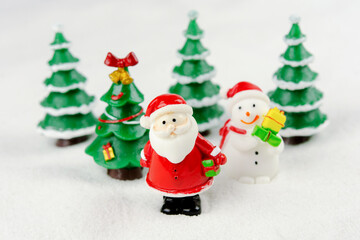 Merry Christmas and happy new year concept. Cute santa claus figure and tree on snow with copy space