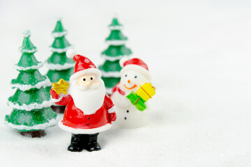 Merry Christmas and happy new year concept. Cute santa claus figure and tree on snow with copy space