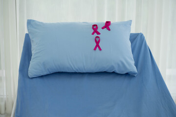Pink ribbon on hospital pillow represents the breast cancer awareness. Healthcare and medicine insurance  concept. sickness recovery concept. 