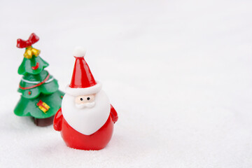 Merry Christmas and happy new year concept. Cute santa claus figure and tree on snow with copy space