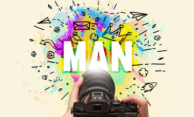 Close-up of a hand holding digital camera with abstract drawing and MAN inscription
