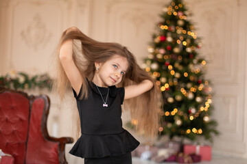 A little girl opens a Christmas present from Santa. Christmas tale. Happy childhood