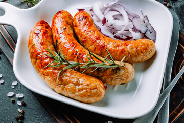  Hot fried sausages with rosemary and onions close-up
