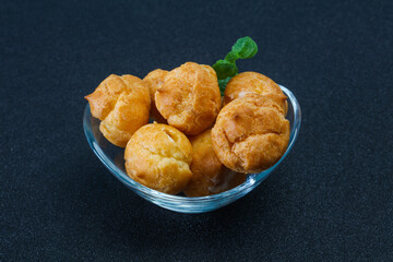 Sweet tasty profiteroles heap in the bowl